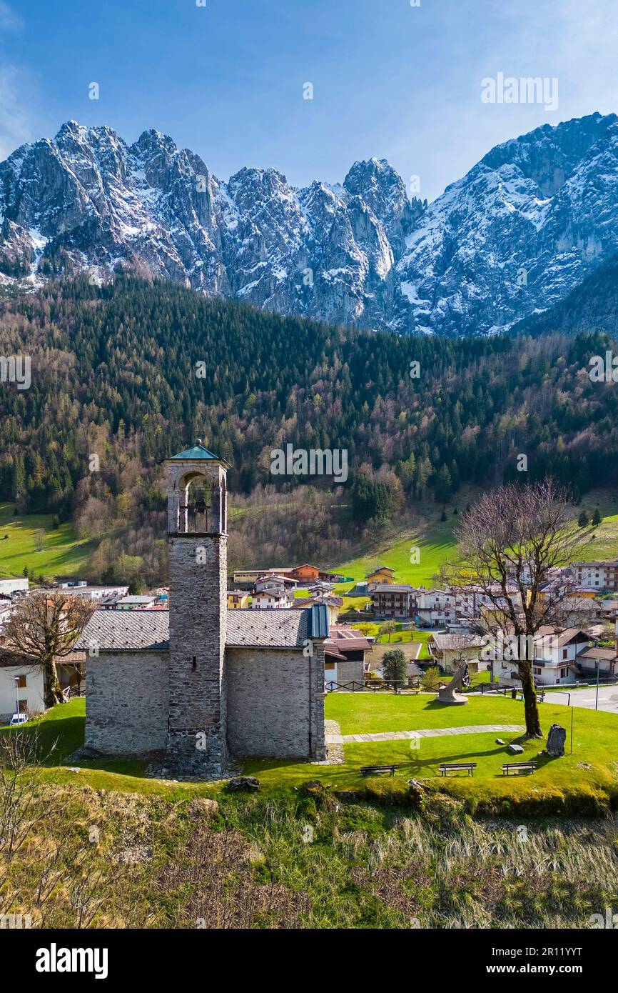 Aerial view of the church called Cesulì with north face of the Presolana mountain in spring. Colere, Val di Scalve, Bergamo district, Lombardy, Italy. Stock Photo
