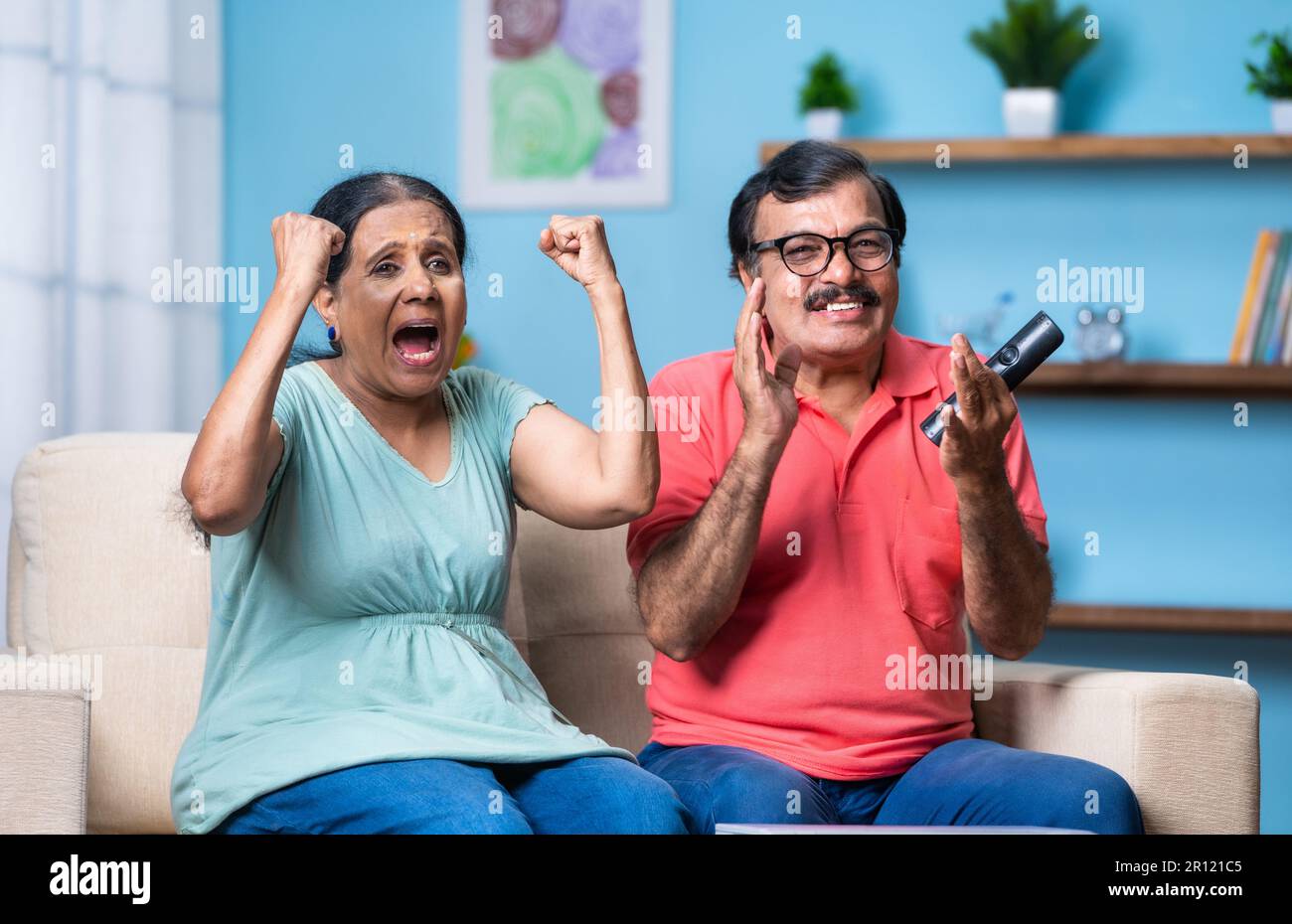 Happy Excited Indian Senior Couple Watching Live Cricket Sports Match happy-excited-indian-senior-couple-watching-live-cricket-sports-match