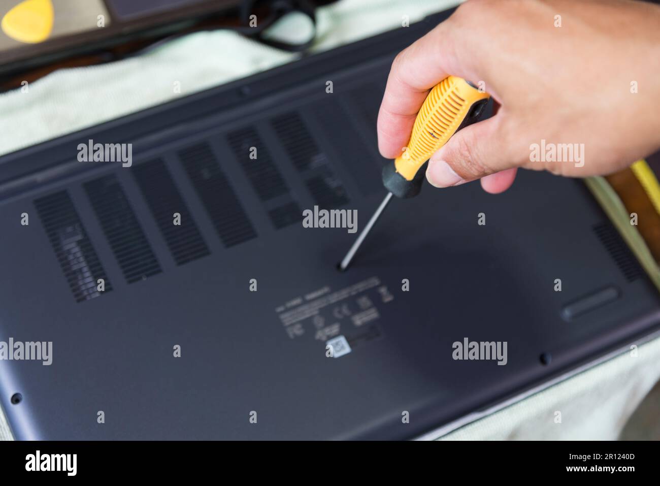 Use screwdriver turn the screw for open laptop case Stock Photo