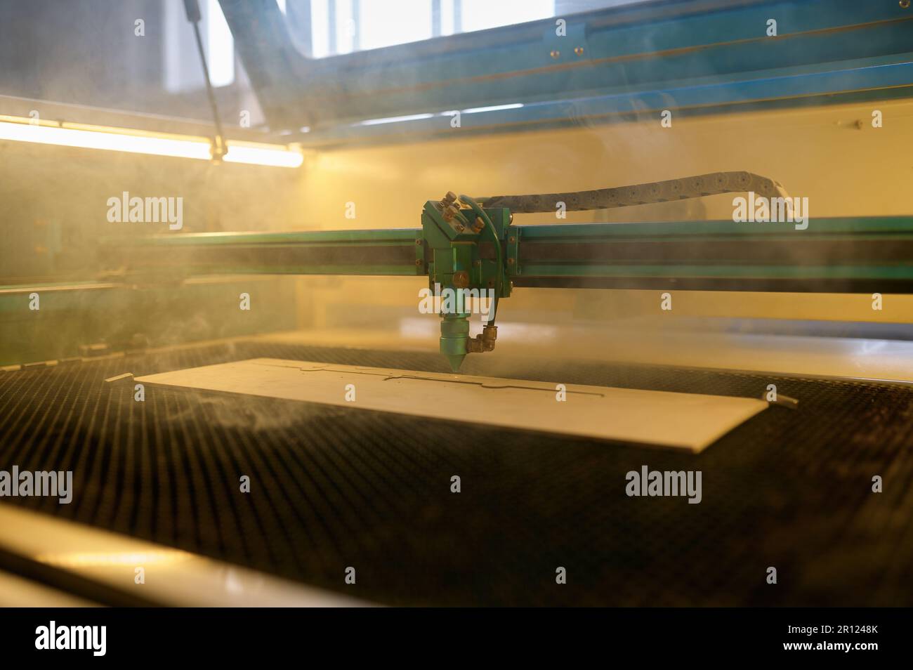 An automated CNC laser machine operating with wooden plank Stock Photo ...