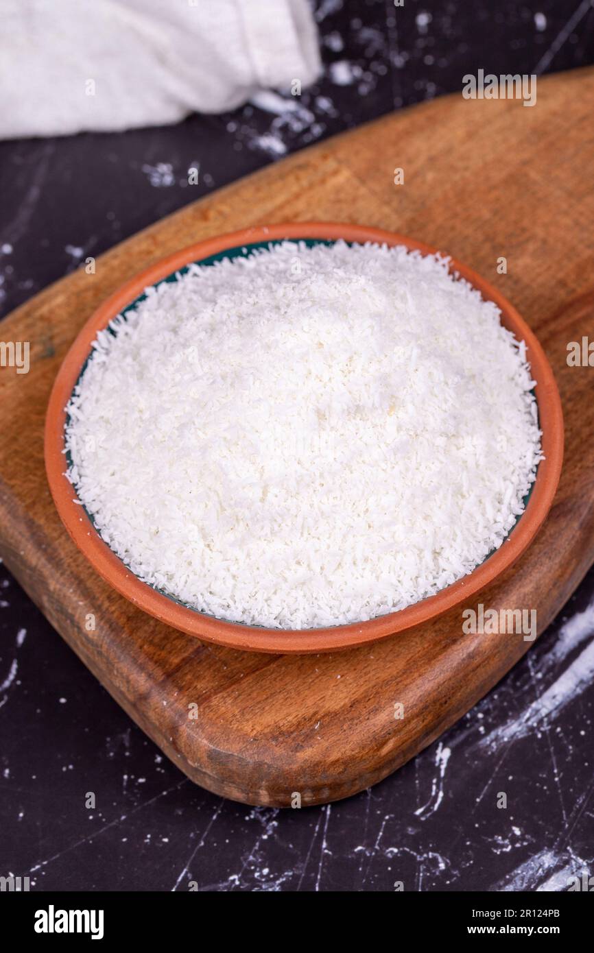 Coconut powder. Grounded coconut flakes on dark background. Earthen