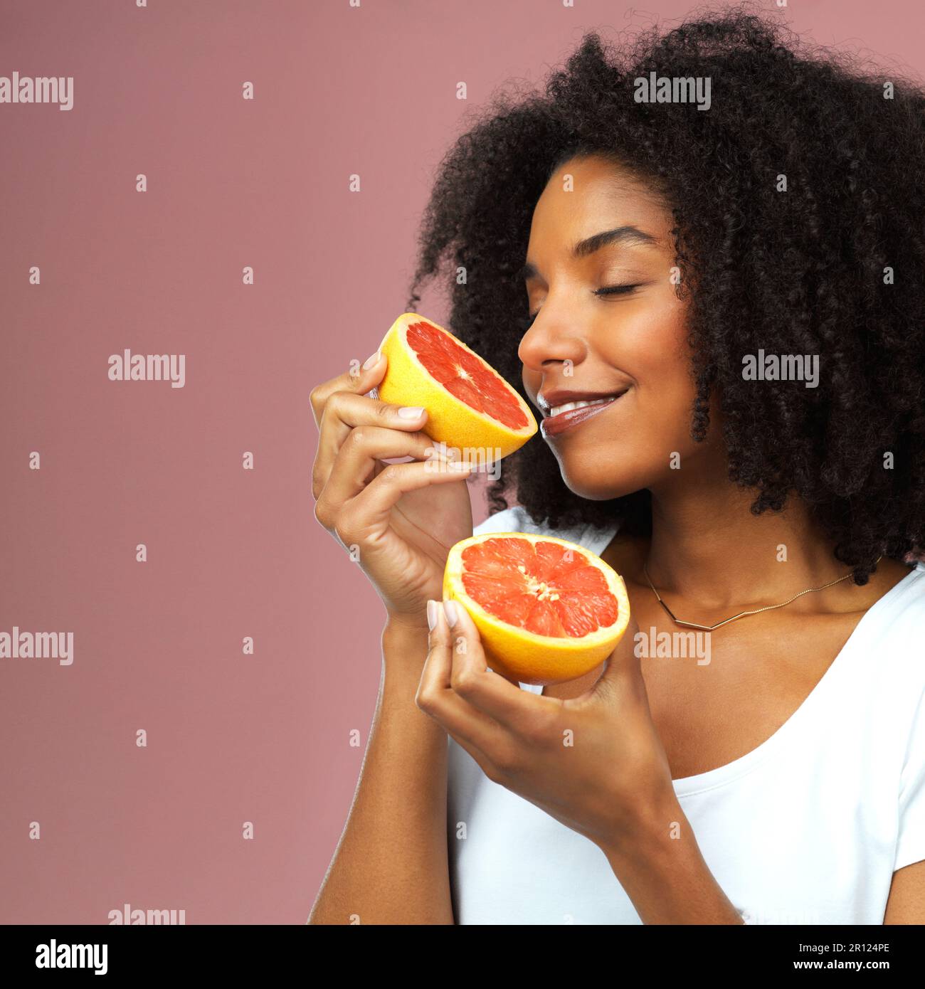 Tastes good and smells divine. Studio shot of an attractive young woman