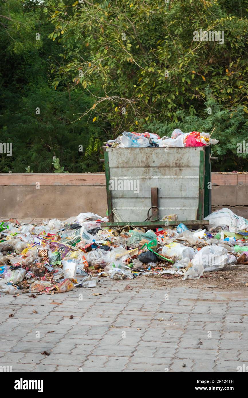 open garbage dust bin liter with plastic begs and waste items at day