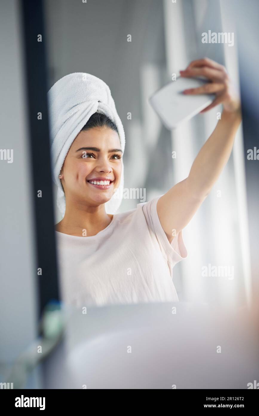 First, let me take a selfie. a beautiful young woman taking selfies in the bathroom at home