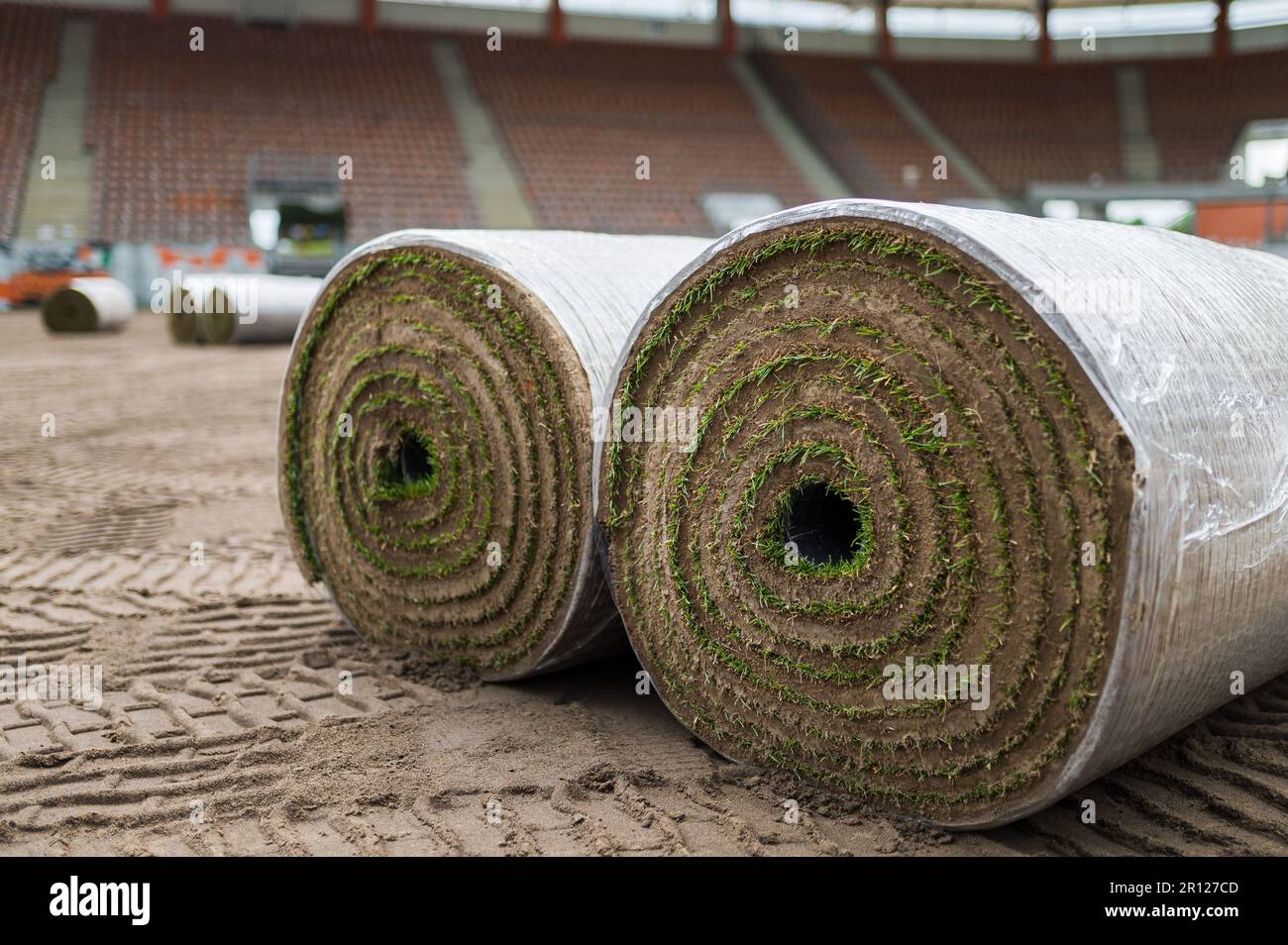 Big rolls of grass lays on a football field at the stadium. Stock Photo