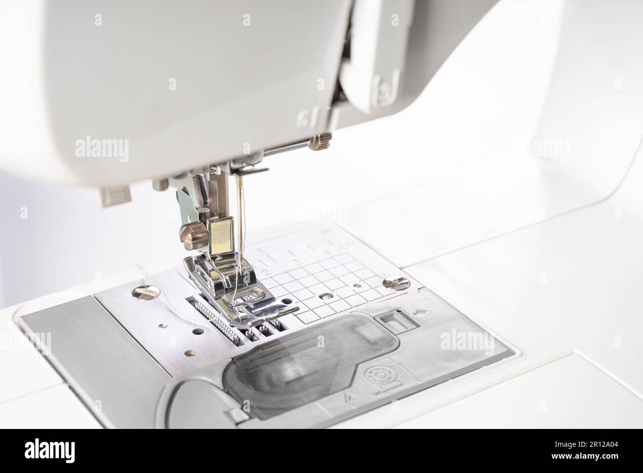 Modern white sewing machine presser foot closeup, macro. Sewing