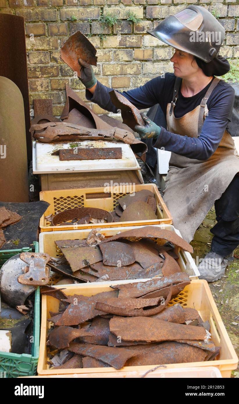 PRODUCTION - 05 May 2023, Saxony, Leipzig: Steel artist Dana Meyer compares metal plates lying in boxes in her backyard, which is part of her studio, to dachshunds for a new installation. Along with smaller metal insects in glass, the unusual life-size sculptures made of steel are among the works that the artist forges freehand and without plastic designs. She uses mostly found steel plates to create forged parts, which she assembles into the unusual figures like a puzzle using a cutting torch and welding equipment. She is represented with her works from 12.5.-20.08.23 at the Galerie Rothamel Stock Photo