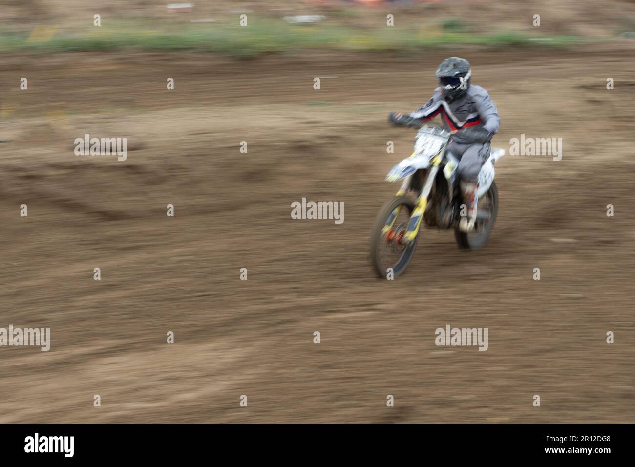 Unrecognized athlete riding a sports motorbike jumping on the air on a motocross race. Fast speed extreme sport. Stock Photo