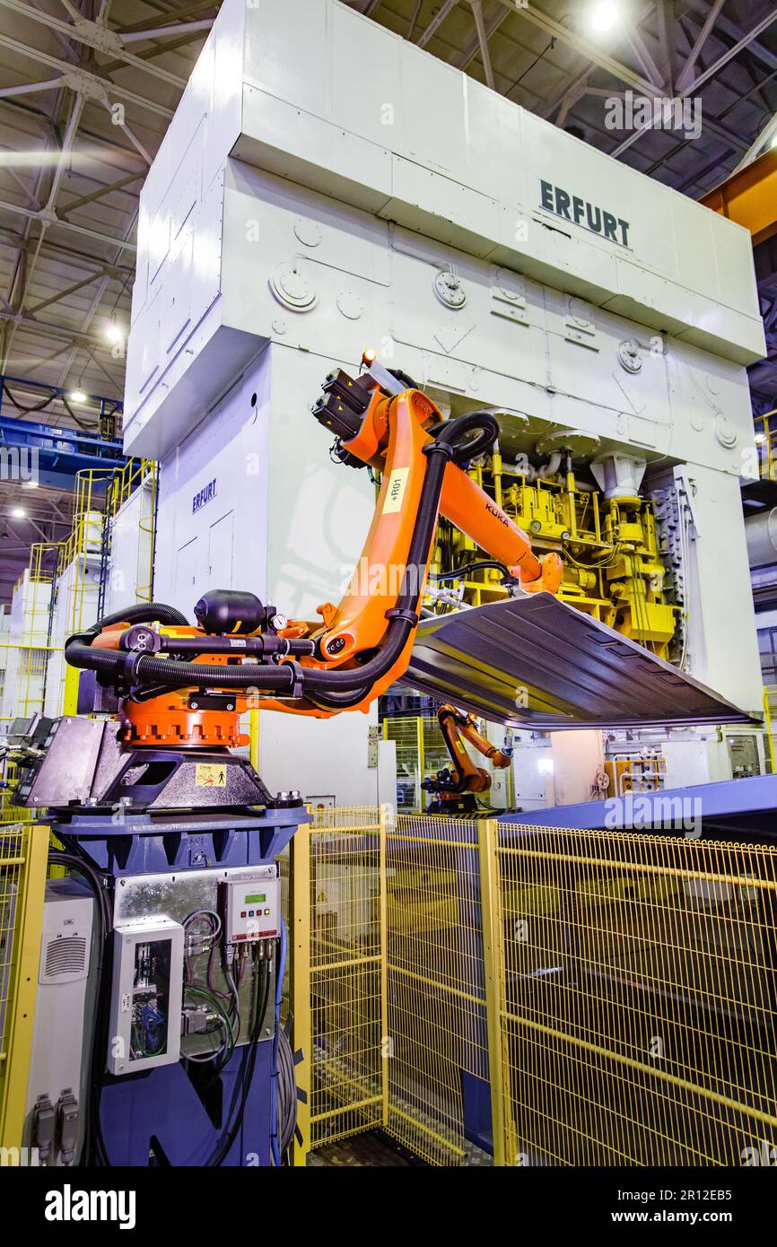 Nizhny Novgorod, Russia - November 21, 2020: GAZ car production plant. Kuka robot manipulator take metal car panel to Erfurt stamping press Stock Photo