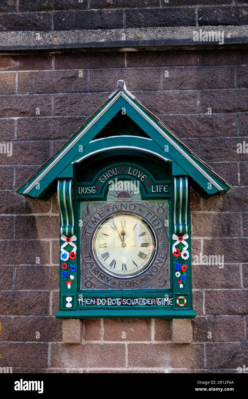 The Cremyll Quay decorative clock at Mount Edgcumbe Country Park is decorated with timely phrases and sayings, Cornwall, England, UK Stock Photo