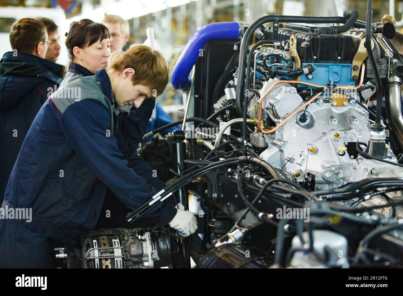 Nizhny Novgorod, Russia - November 21, 2020: GAZ car production plant. Young man assembling motor and transmission parts Stock Photo