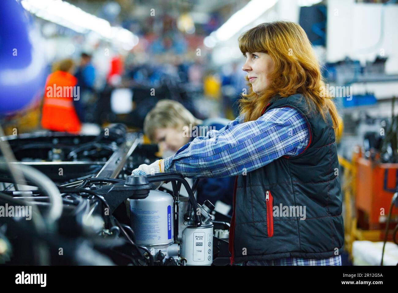 Nizhny Novgorod, Russia - November 21, 2020: GAZ car production plant. Young woman assembling lorry parts Stock Photo