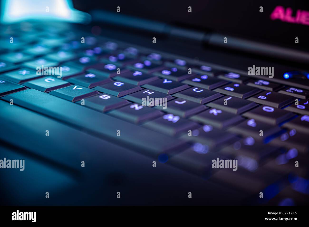 A sleek black laptop computer with illuminated keys, creating an ...