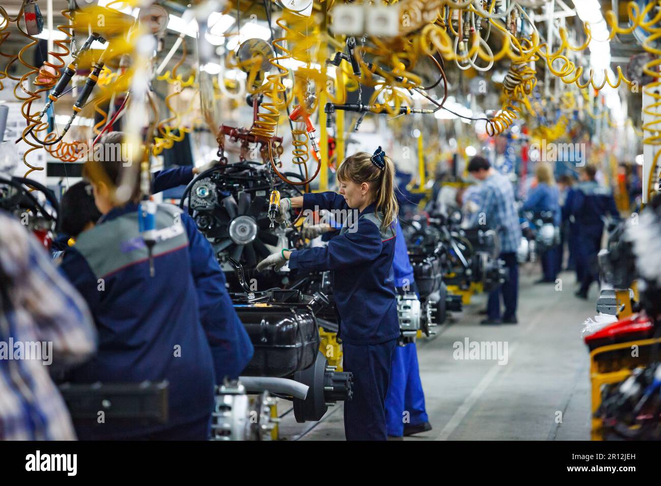 Nizhny Novgorod, Russia - November 21, 2020: GAZ car production plant. People work on assembling line. Young woman in focus only. Stock Photo