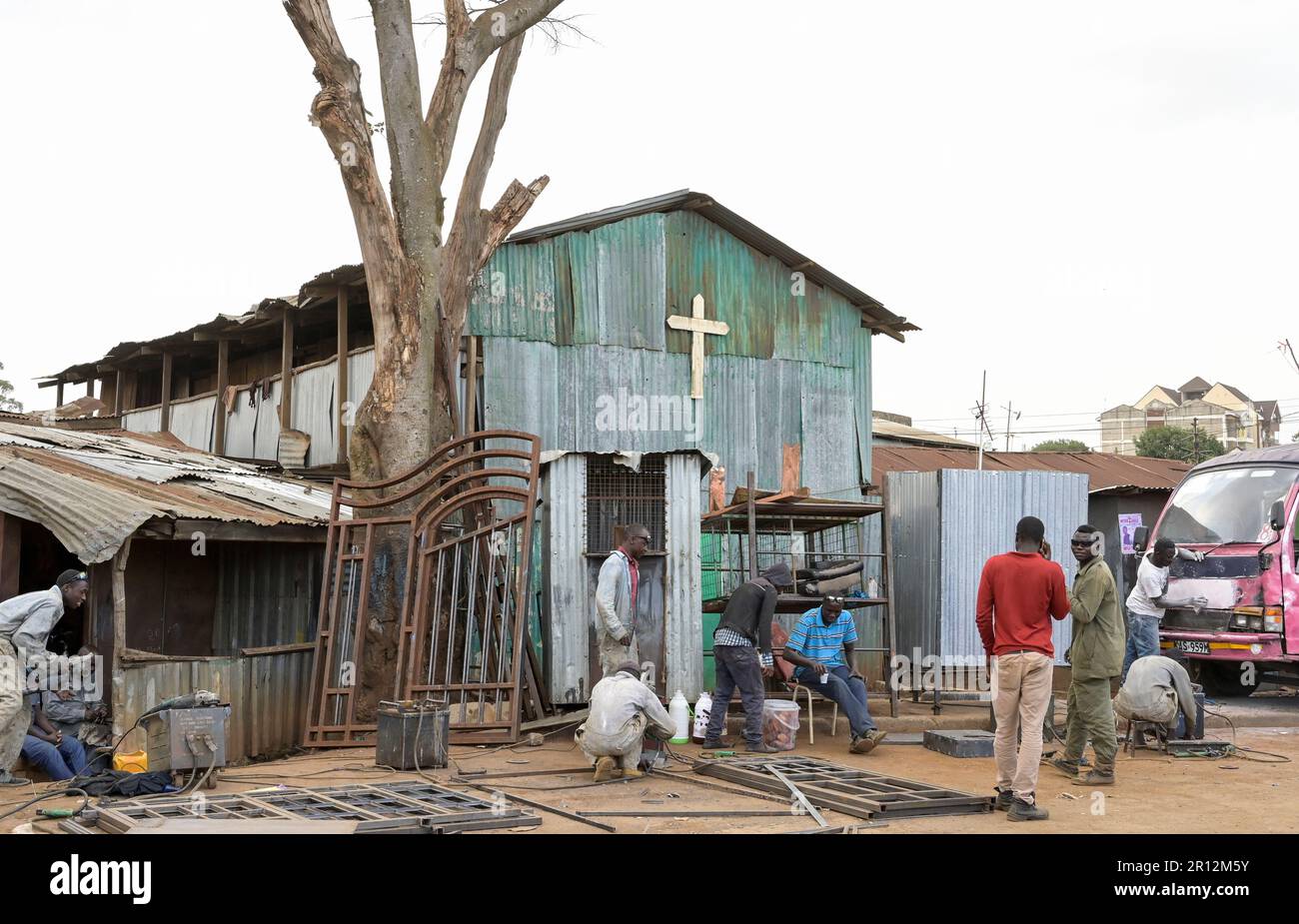 KENYA, Nairobi, Kibera slum, free or pentecostal church in timber hut and roadside small scale business, metal workshop / KENIA, Nairobi, Slum Kibera, Kleingewerbe, Metallbau vor freier Kirche Stock Photo