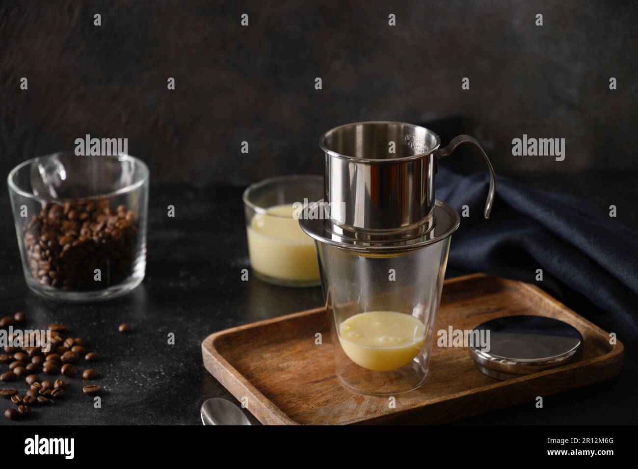 https://c8.alamy.com/comp/2R12M6G/traditional-method-of-making-of-vietnamese-coffee-with-sweet-condensed-milk-in-glass-cup-on-black-background-close-up-2R12M6G.jpg