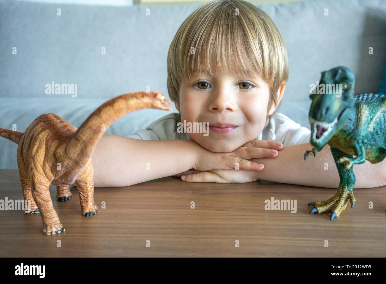 Child playing with colorful toy dinosaurs. Educational toys for kids