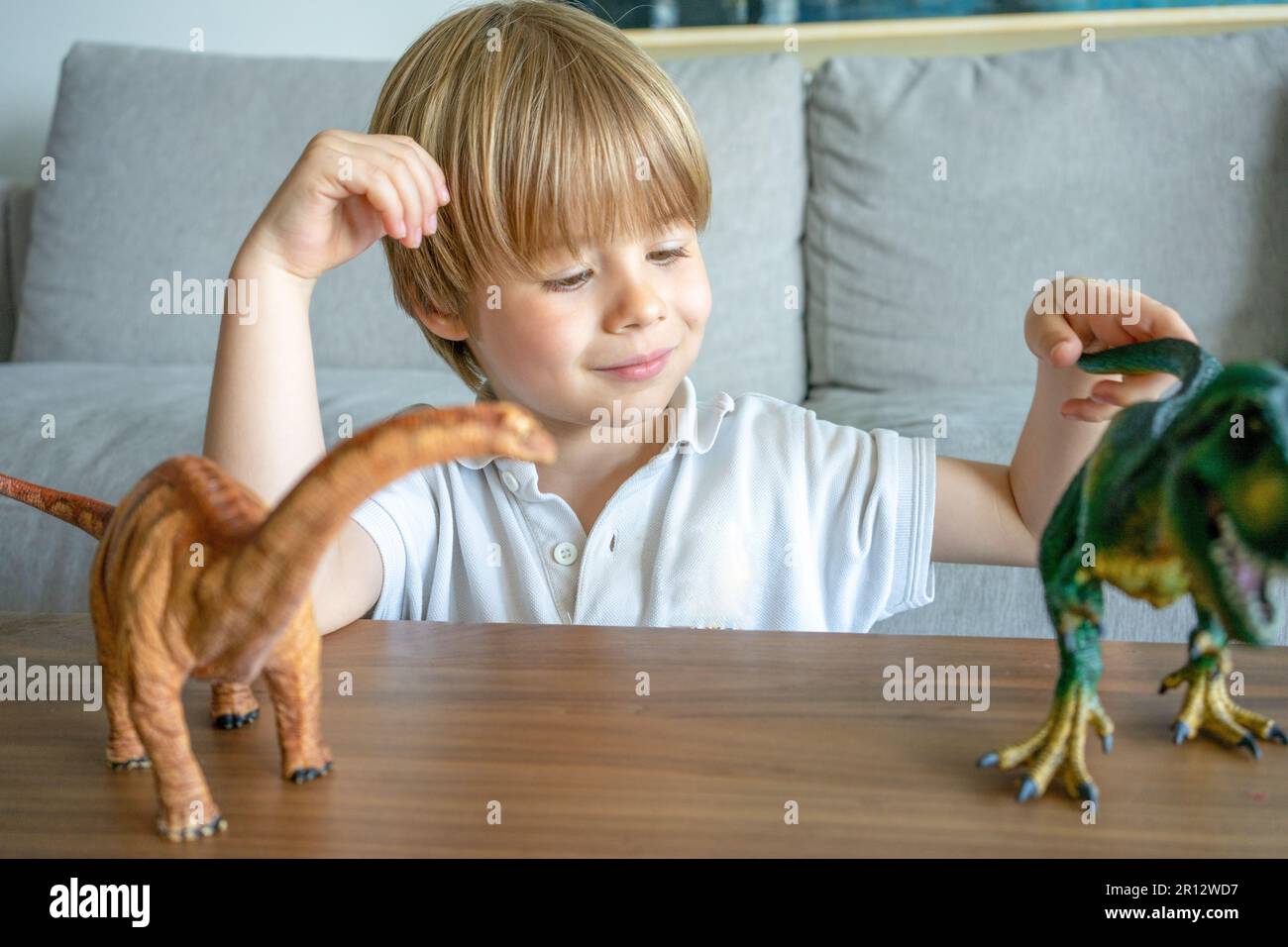 Child playing with colorful toy dinosaurs. Educational toys for kids