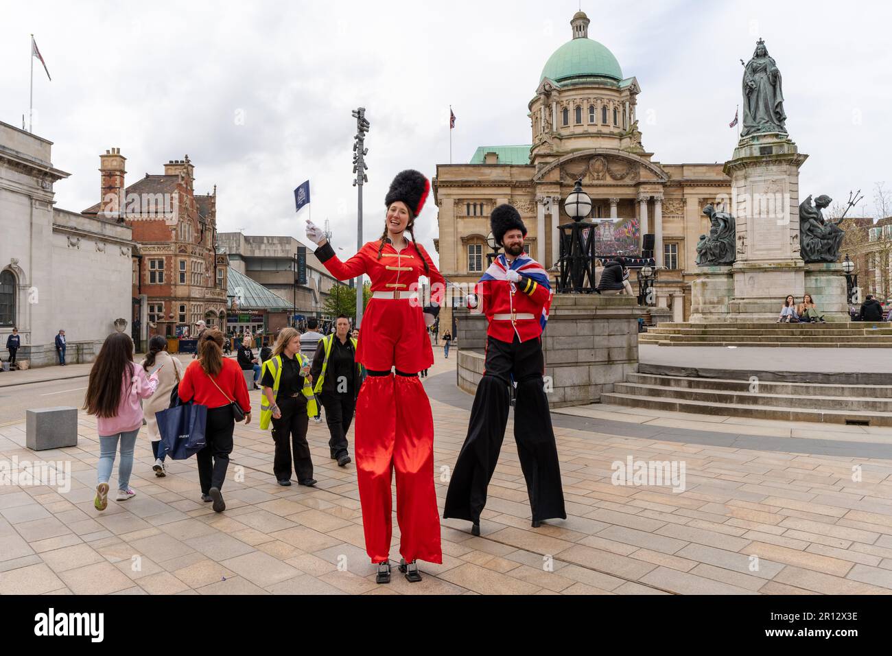 Stilt walkers dressed up in fancy dress military costumes greet people in Kingston upon Hull, UK, on the coronation day of King Charles III Stock Photo