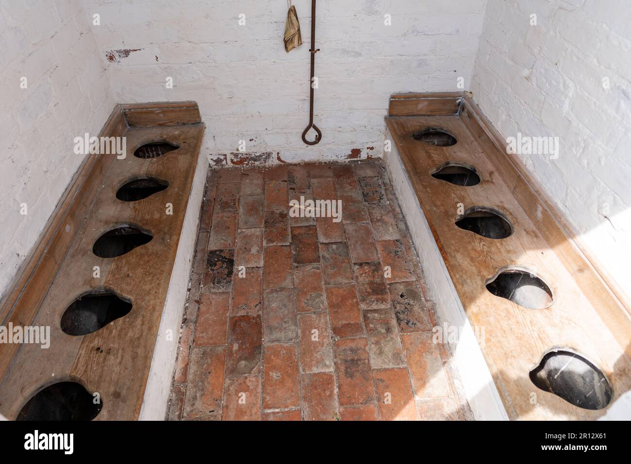 Child-sized Victorian communal toilets in an outhouse at the Wilderspin