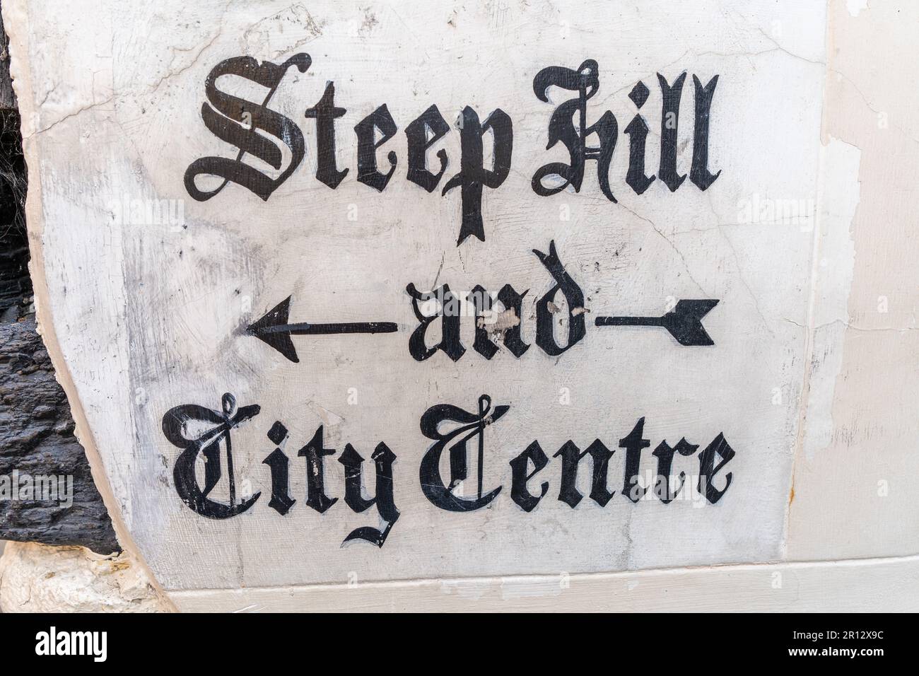 Quaint historic stone carved sign on a wall in Lincoln,  UK directing people down Steep Hill to the City Centre. Stock Photo