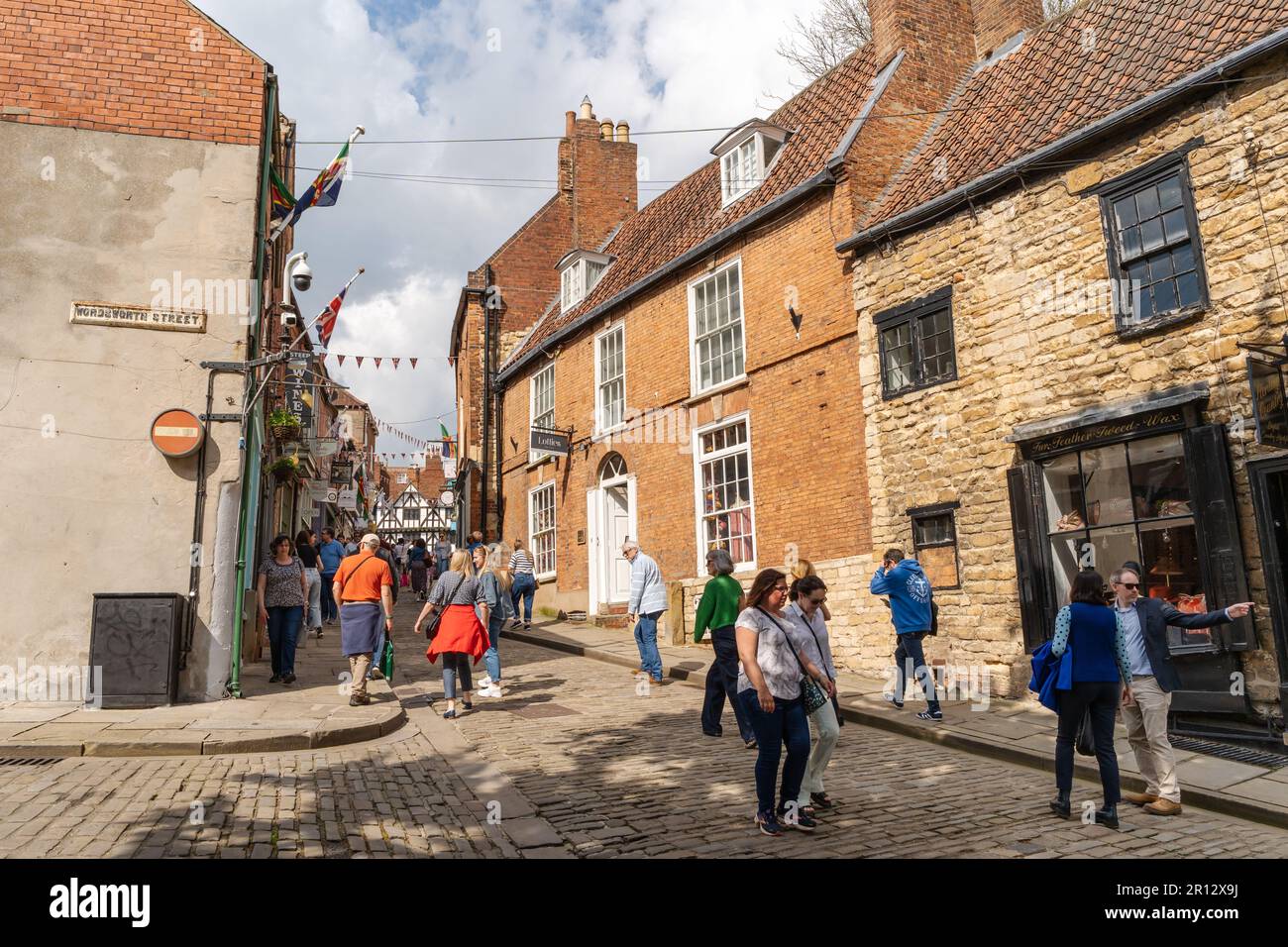 People walking Steep Hill, Lincoln, UK, a popular tourist attraction in the city, due to its independent retailers and olde worlde charm. Stock Photo