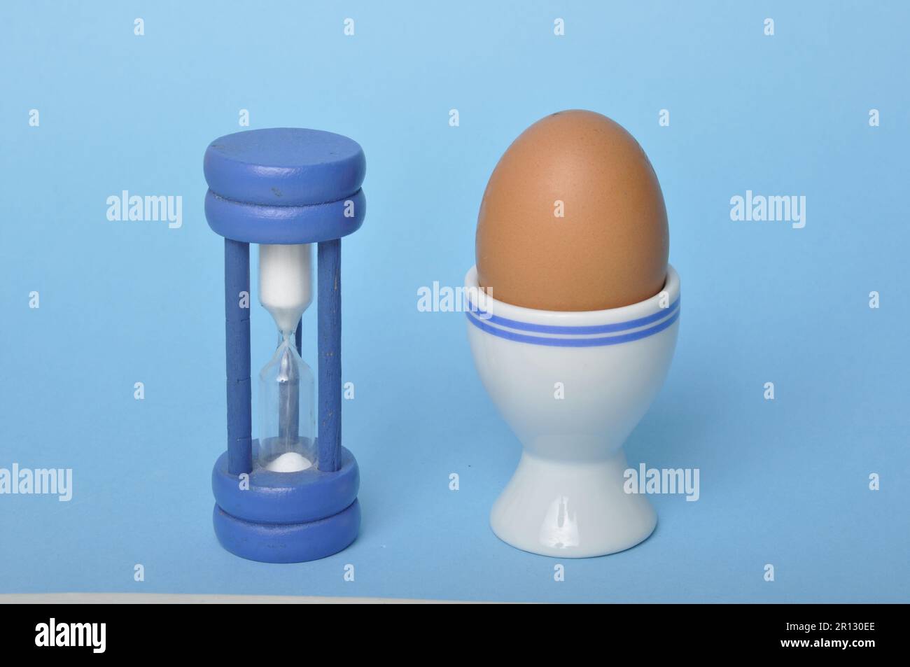 Boiled egg and hourglass on a blue background Stock Photo