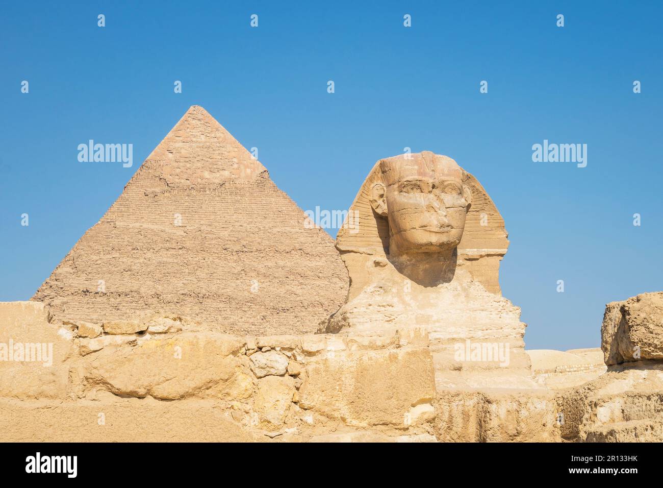 closeup of the face of the Great Sphinx with pyramid in the background ...
