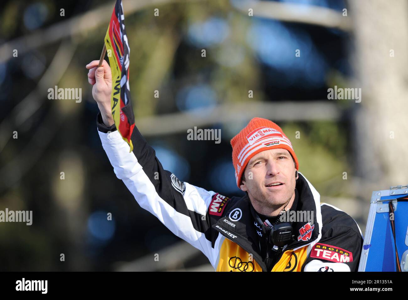 Werner Schuster, Bundestrainer Skisprung, Porträt winkt mit einer Fahne