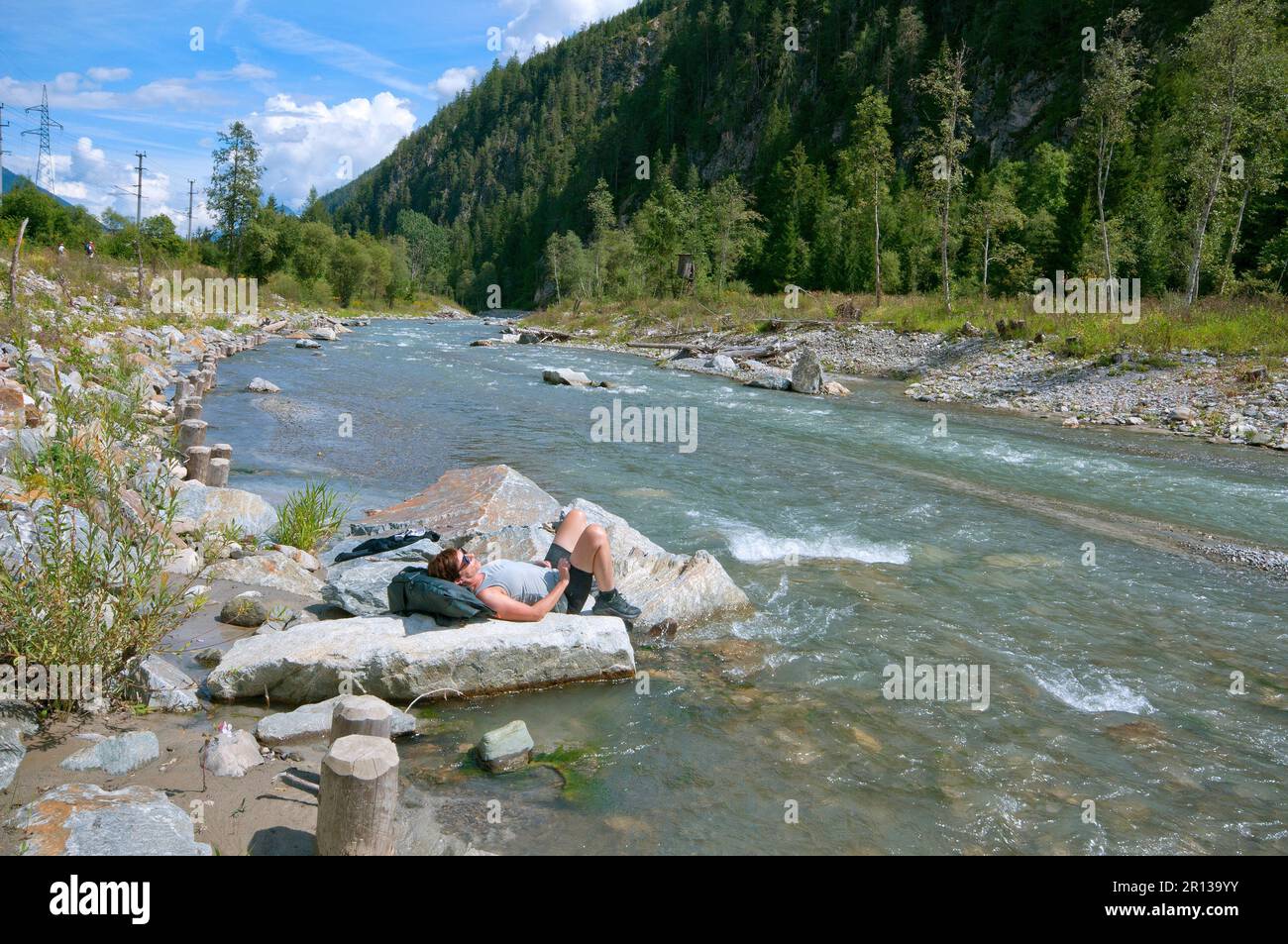 Woman relaxing and sunbathing on the bank of the Drava River, East Tyrol, Austria Stock Photo