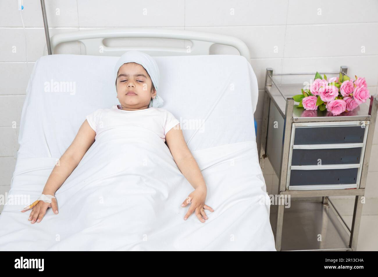 Smiling little girl child patient lying at hospital bed undergoing