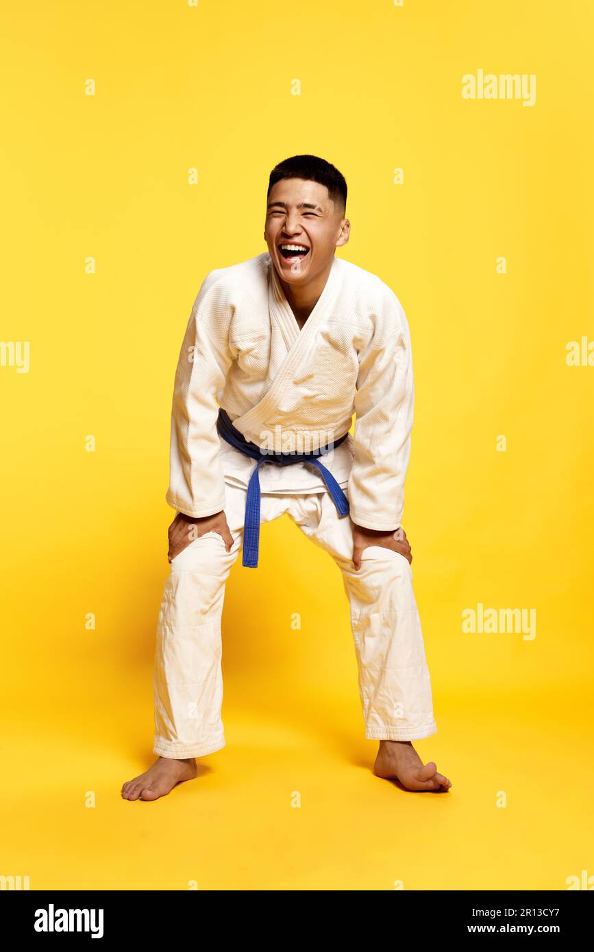 Portrait with cheerful young man, taekwondo, karate athlete wearing