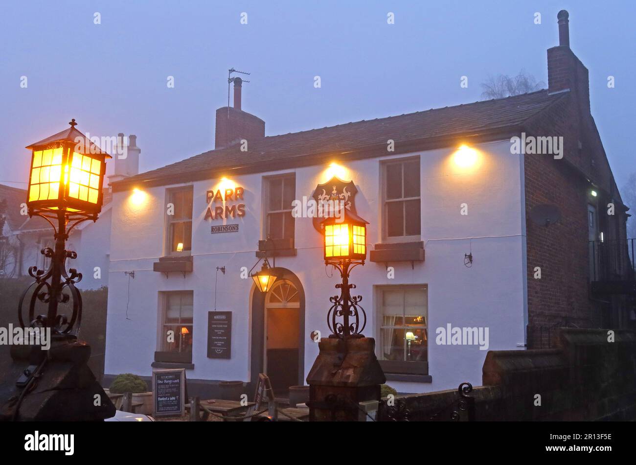 The Parr Arms pub in Winter fog at dusk, Church Lane, Grappenhall, Warrington, Cheshire, England, UK, WA4 3EP Stock Photo