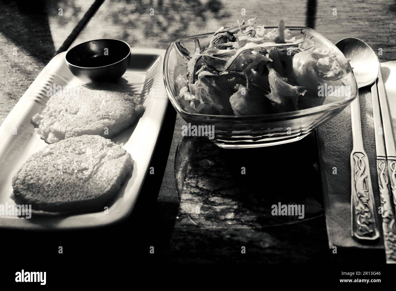 Traditional Korean appetizers. Fried soy bean galettes and salad. Selective focus. Black white