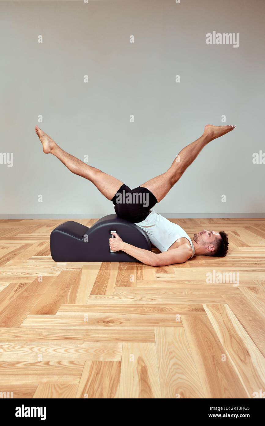 Man doing exercises on pilates reformer, pilates gymnastics reformer