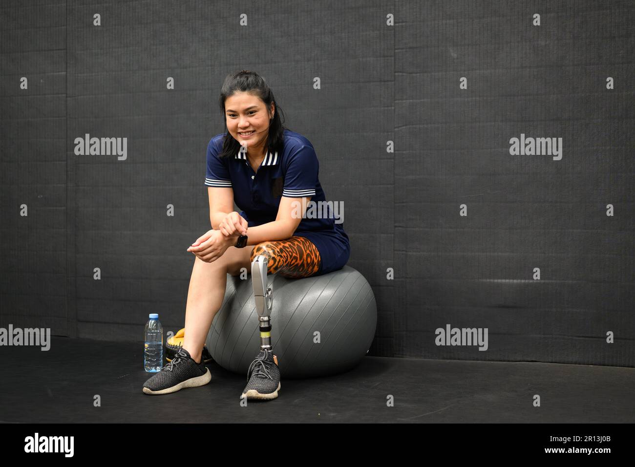 Portrait of disabled athlete woman with prosthetic leg doing exercise ...