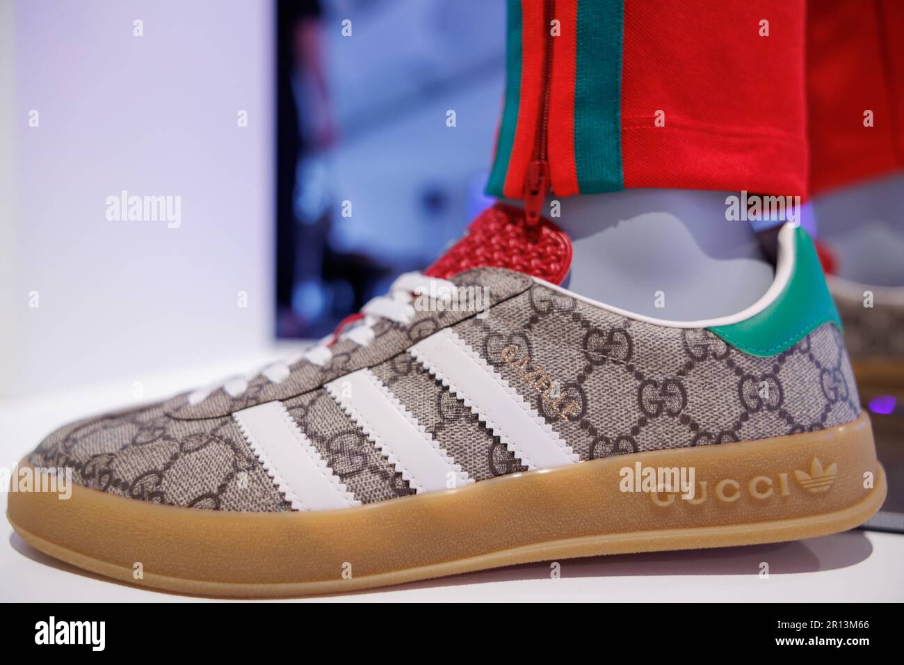 11 May 2023, Bavaria, Fürth: The logo of sporting goods manufacturer adidas  AG and the lettering of fashion company Gucci can be seen on the sidelines  of the adidas Annual General Meeting