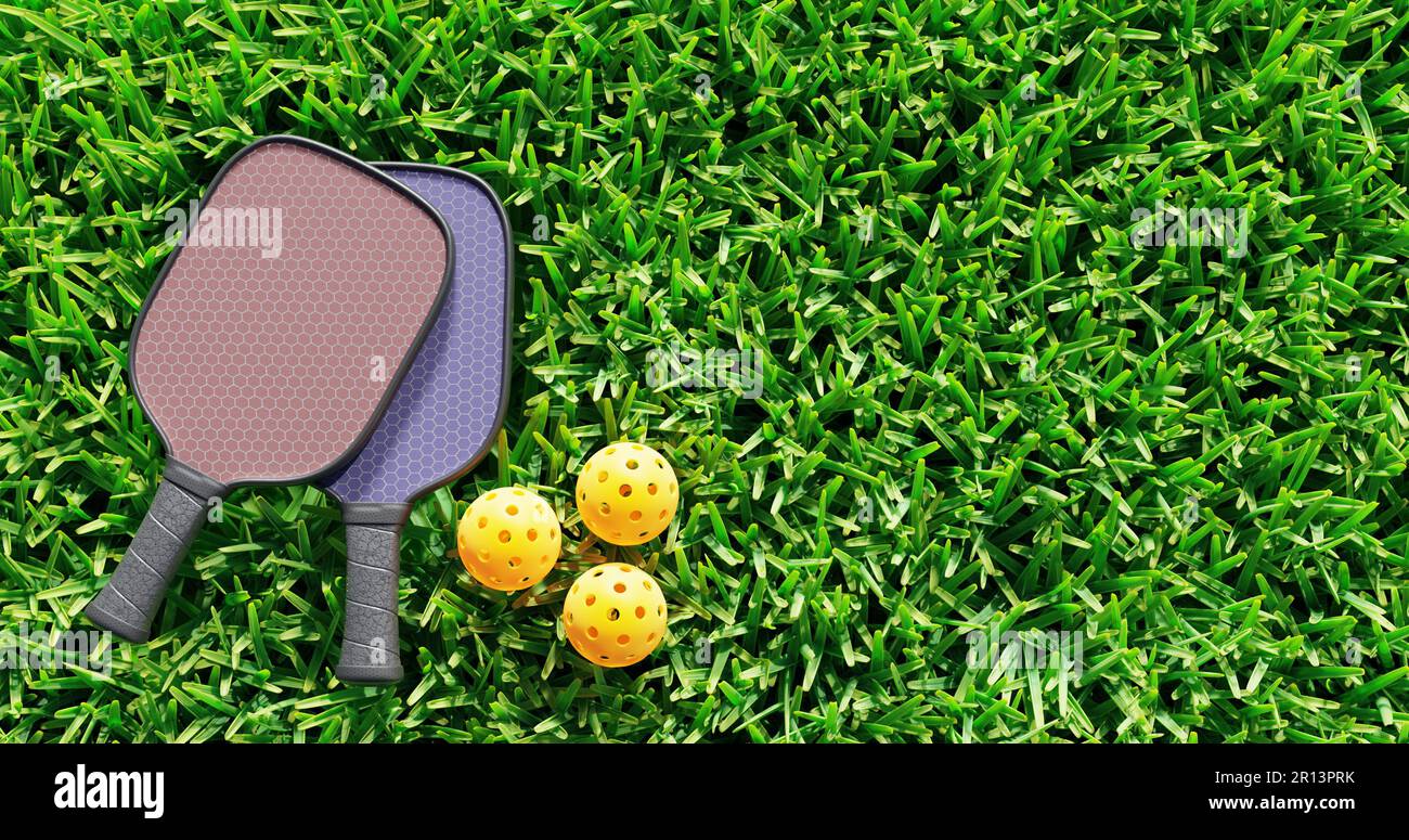 Pickleball. Two rackets and sports balls on the green grass of the lawn