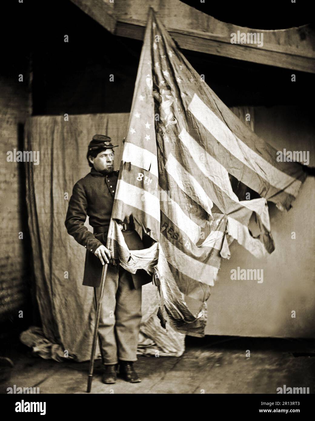 A battle scarred flag of the Pennsylvania Infantry held by a Union soldier.  Photograph from the Mathew Brady Collection. Photographer unknown. This archival print is available in the following sizes: Stock Photo