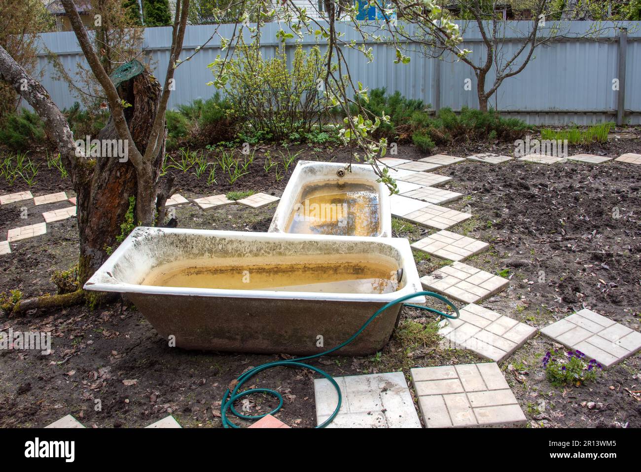 Old castiron tubs in the garden filled with water for irrigation in