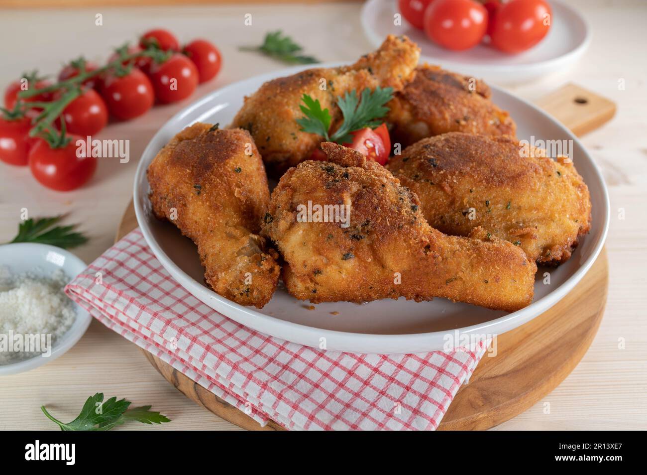 Parmesan breaded chicken drumsticks and shanks on a platter Stock Photo