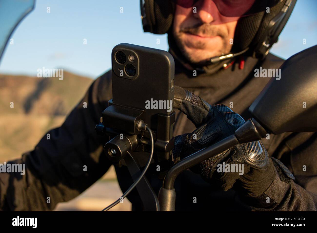 Biker setting the route on the gps map of his smartphone anchored to