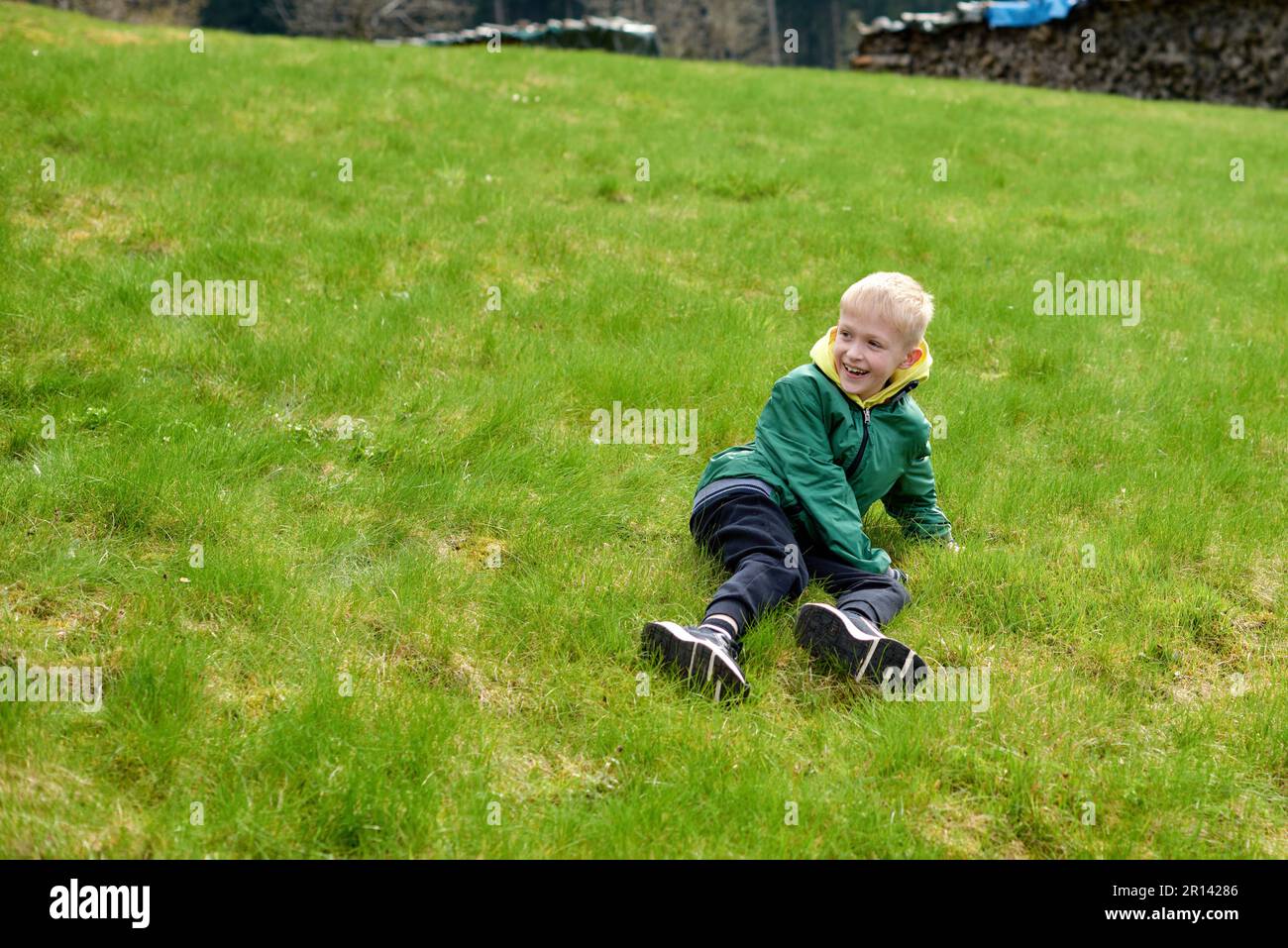 Fun teenager sits on hillside. Boy resting in mountains. School boy