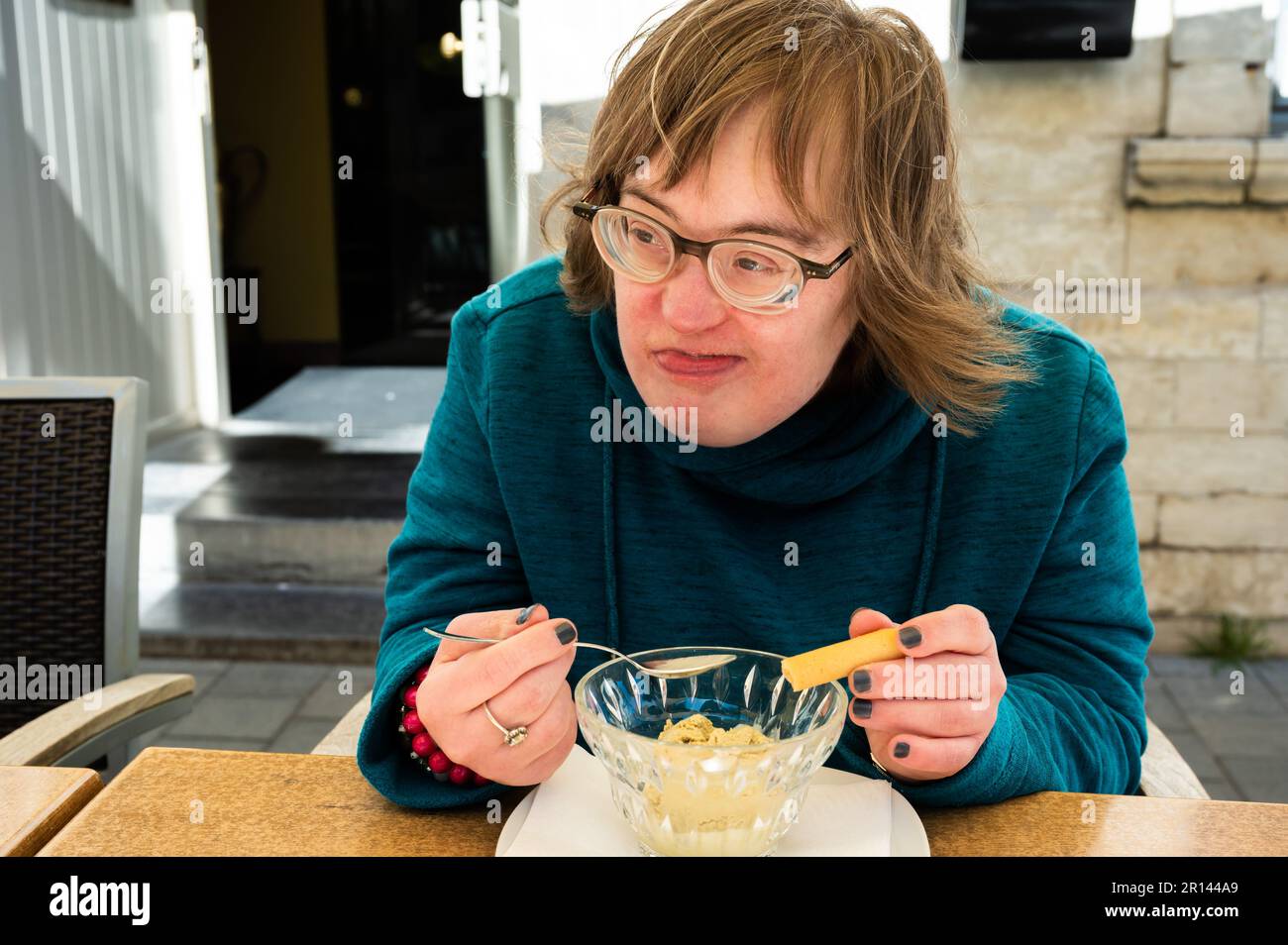 Portrait of a happy 40 yo woman with Down Syndrome eating an ice cream, Tienen, belgium Stock Photo
