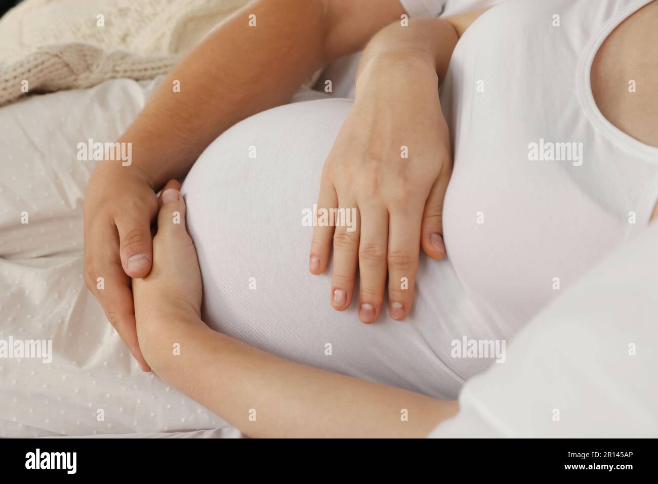 Man hugging his pregnant wife on bed, closeup Stock Photo - Alamy