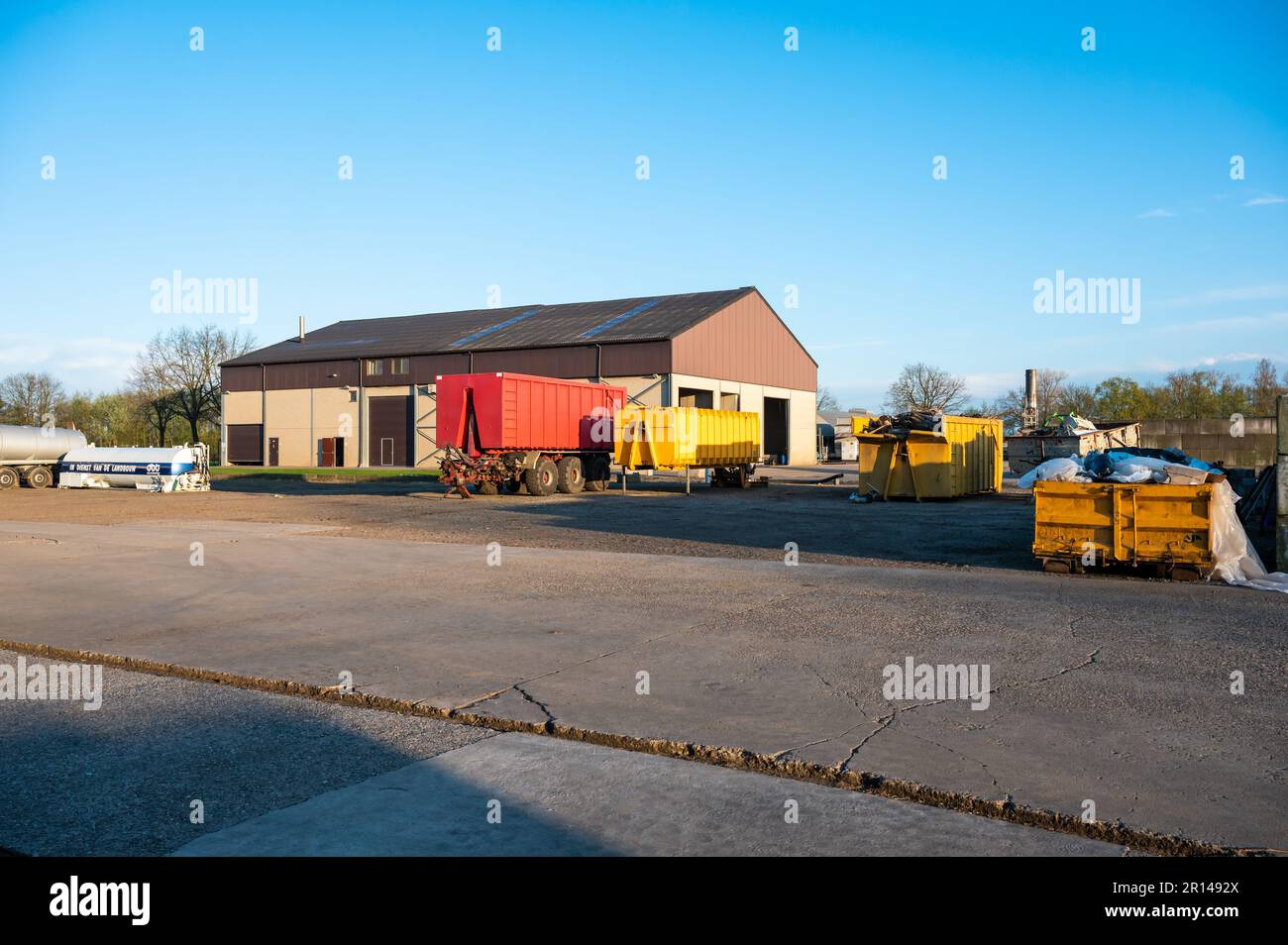 Meerhout, Antwerp Province, Belgium - April 25, 2023 - The main court of a modern farm with barns and agriculture vehicles Stock Photo