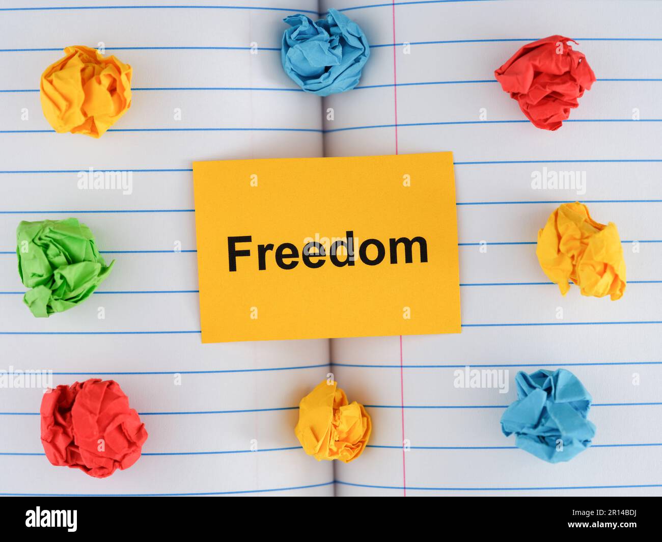 A yellow paper note with the word Freedom on notebook sheet with some ...