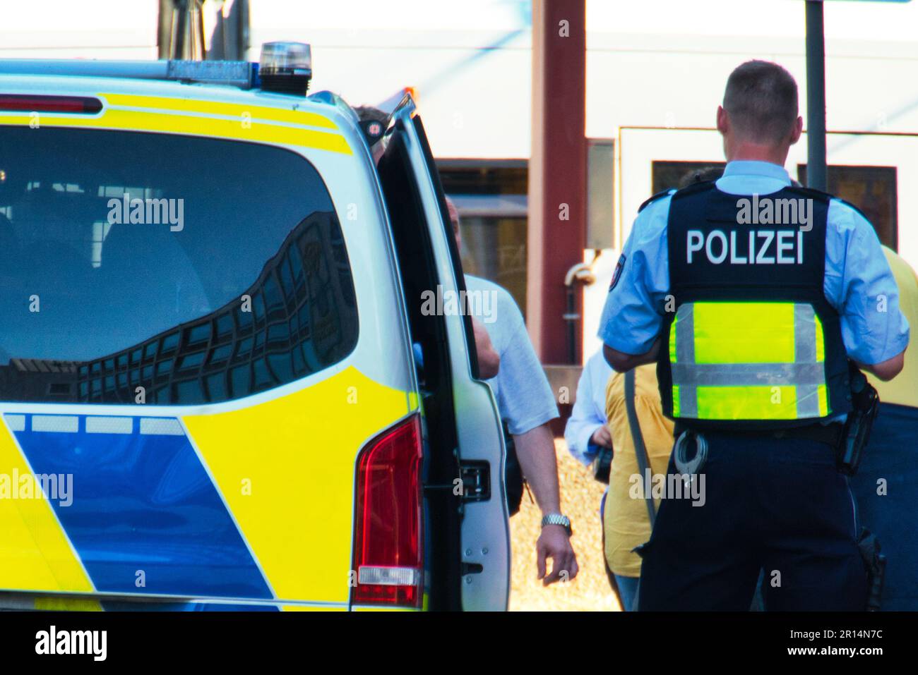 Policeman next to a police car when checking a person Stock Photo
