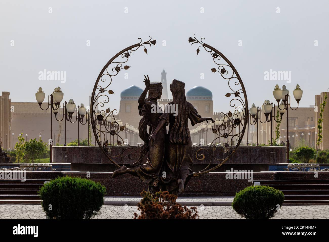 a silhouette statue of two figures with a garland frames the view of