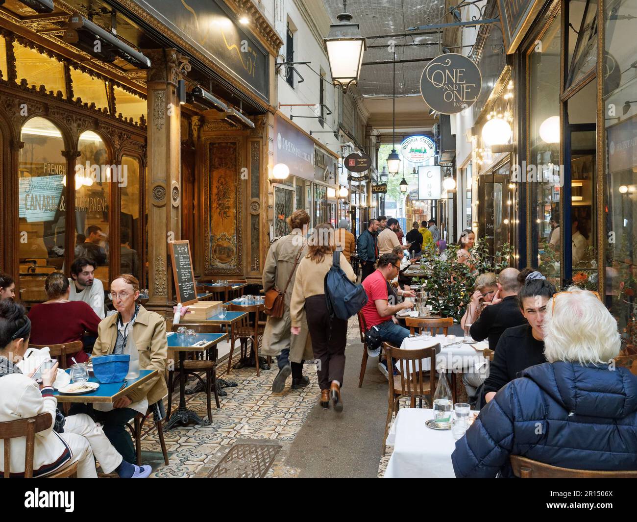 View looking along the bars and restaurants of the covered Passage des Panoramas passageway in Paris France Stock Photo